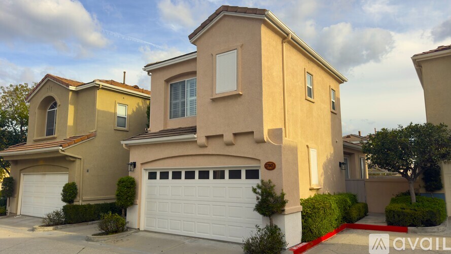A beige house with a white garage door is for sale.