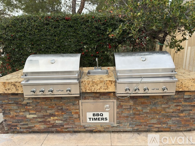 A BBQ timers sign is on a brick wall.