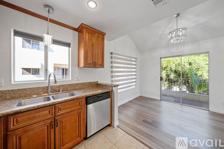 A kitchen with wooden cabinets and a stainless steel dishwasher.