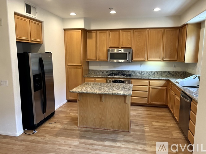 A kitchen with wooden cabinets and a granite countertop.