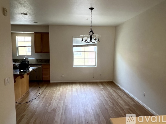 A room with wooden floors and a chandelier hanging from the ceiling.