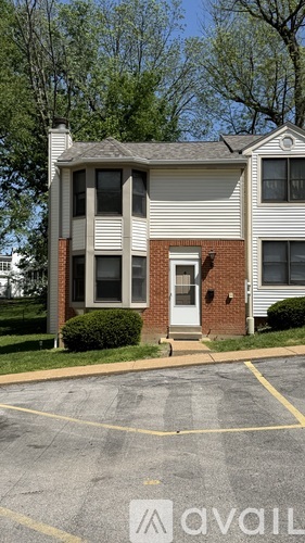 A two-story house with a brick front and a white siding.