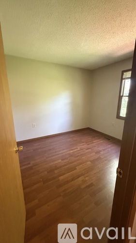 A room with wooden floors and a window.