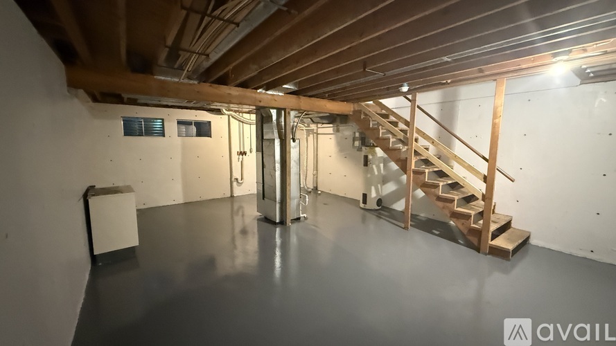 A spacious room with a staircase and a radiator.