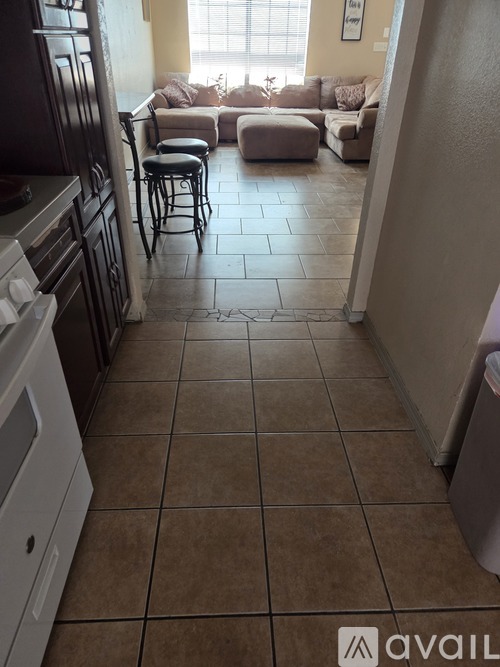 A kitchen with brown tiles on the floor.