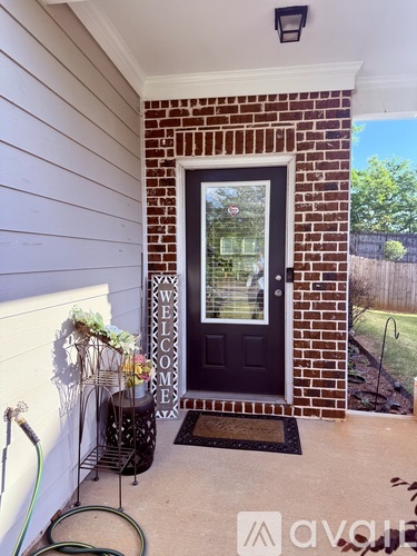 A front door with a glass window and a doormat on the floor.