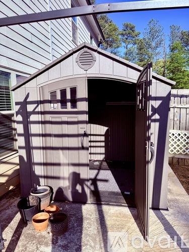 A small building with a door open and a table with bowls on it.