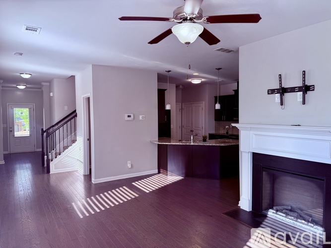 A living room with a fireplace and a ceiling fan.