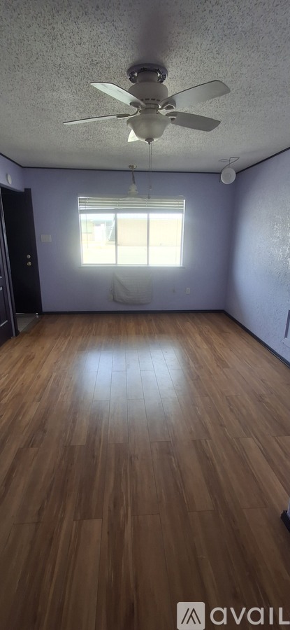 A room with wooden flooring and a ceiling fan.