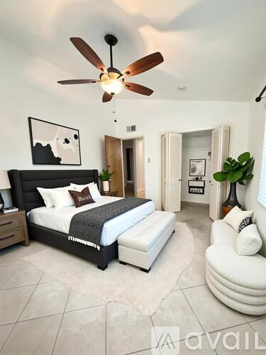 A bedroom with a large bed and a ceiling fan.