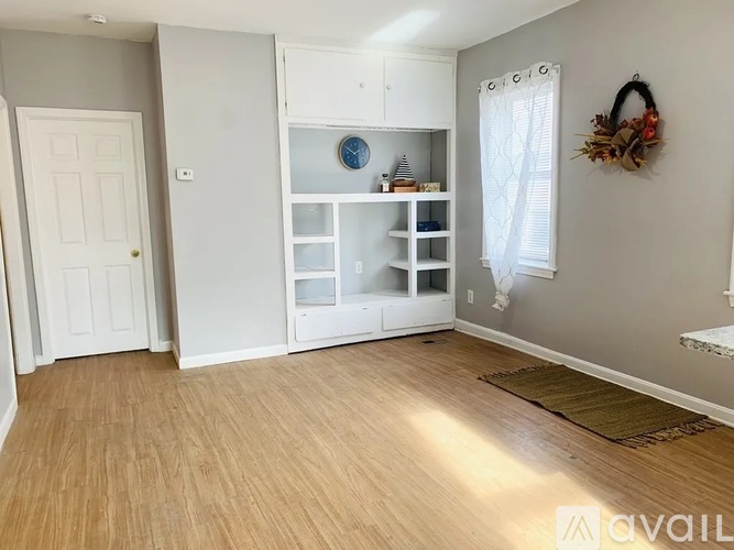 A room with a white door and a wreath on the wall.