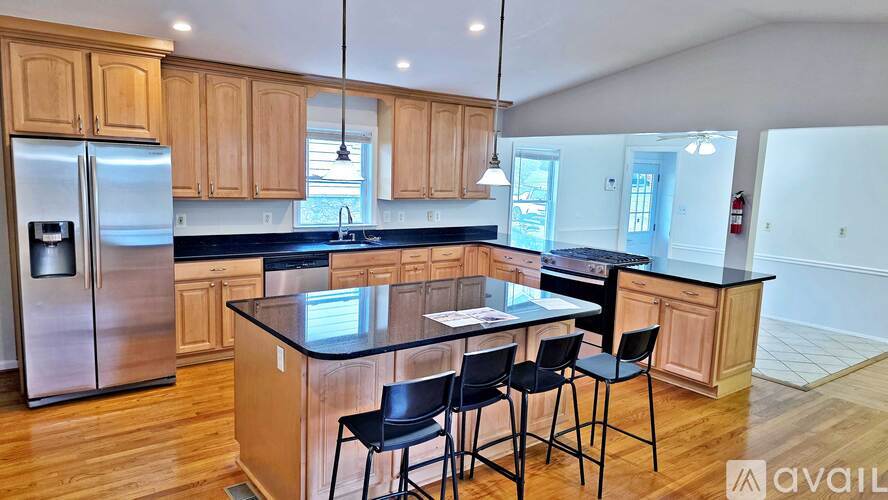 A kitchen with wooden cabinets and a black countertop.