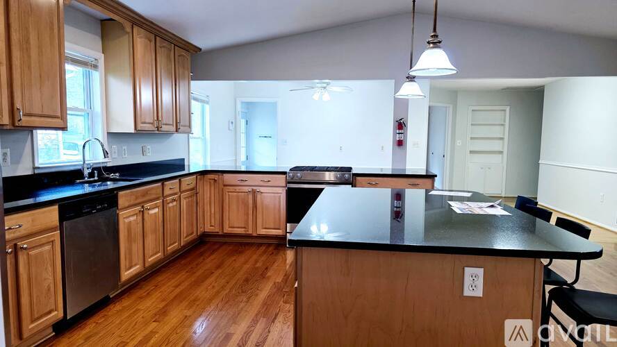 A kitchen with wooden cabinets and black countertops.