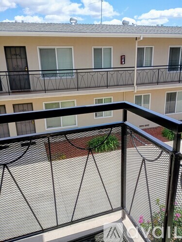 A balcony with a black railing and a view of a building.