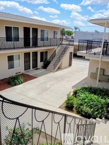 A balcony with a black railing and a concrete floor.