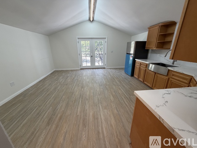 A kitchen with wooden flooring and a countertop is available.