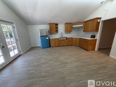 A kitchen with wooden cabinets and a blue cooler.