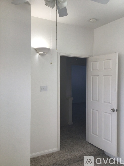 A white door is in a room with a ceiling fan.