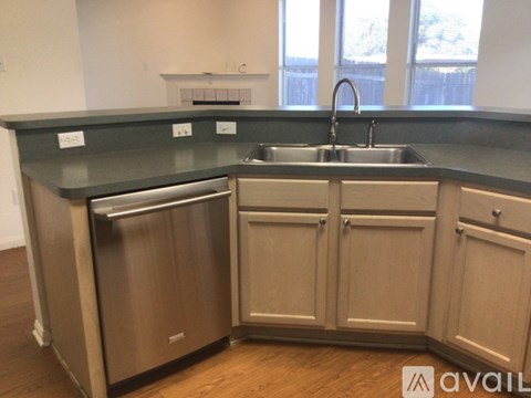 A kitchen with a stainless steel dishwasher and a sink.