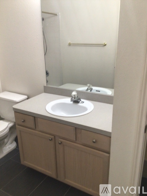 A bathroom with a sink, toilet and mirror.