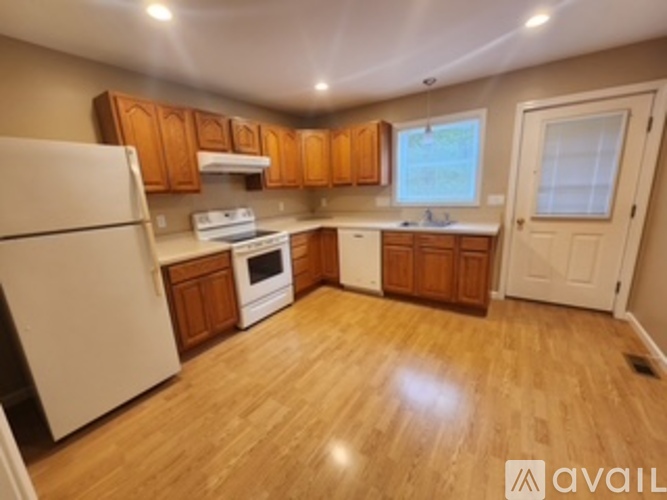 A kitchen with wooden cabinets and a white fridge.
