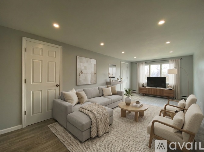 A modern living room with a grey sofa, a wooden coffee table, and a television.