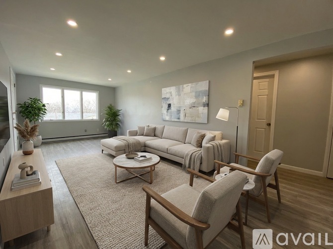 A living room with a large couch, a coffee table, and a lamp.
