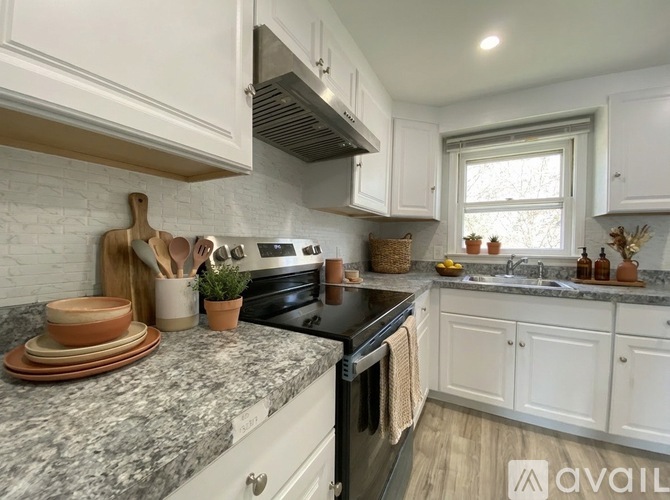 A kitchen with white cabinets and a granite countertop.