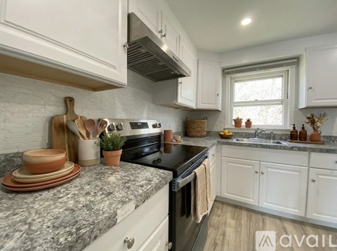 A kitchen with white cabinets and a granite countertop.