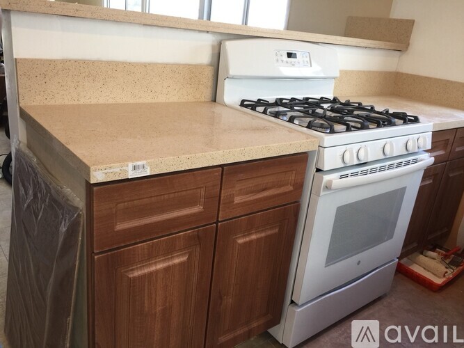 A kitchen with a white stove and wooden cabinets.