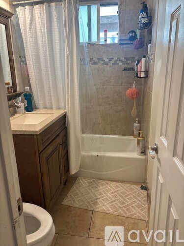A bathroom with a toilet, sink, and shower.