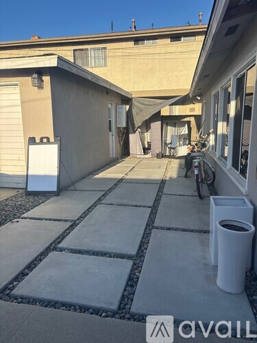 A patio with a white trash can and a bicycle.