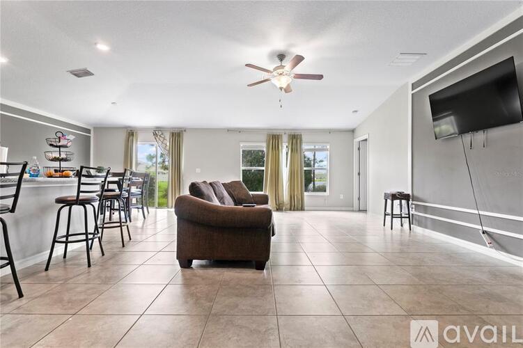 A living room with a brown couch and a ceiling fan.