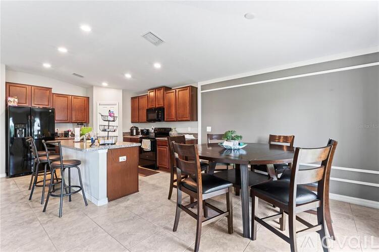 A kitchen with a table and chairs.