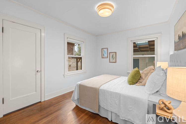 A bedroom with a bed, a window, and a door.