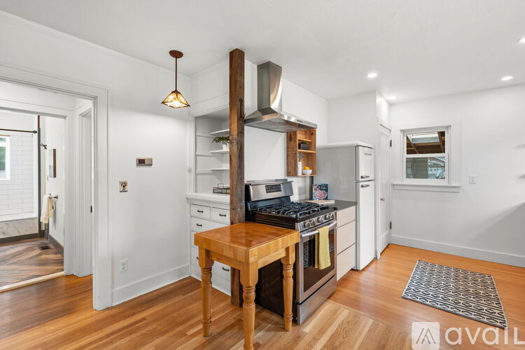 A kitchen with a wooden island and stove top oven.