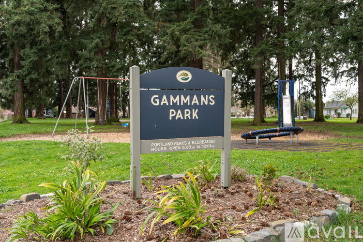 A sign for Gammans Park is displayed in front of a playground.