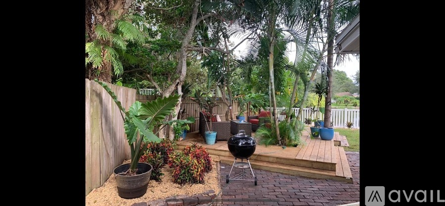 A backyard with a grill and a wooden deck.
