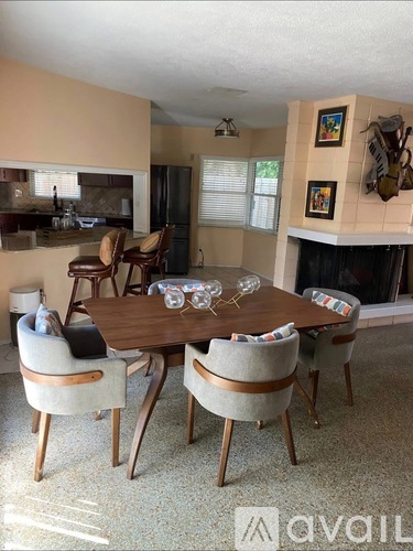 A dining room with a wooden table and chairs.