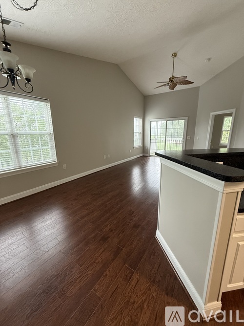 A room with wooden floors and a ceiling fan.