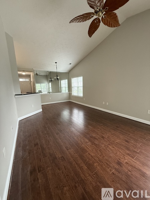 A room with wooden flooring and a ceiling fan.