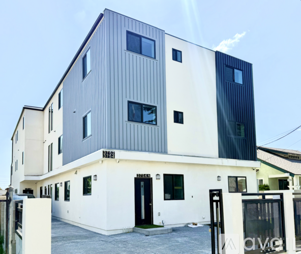 A modern two-story building with a combination of white and dark grey exterior.
