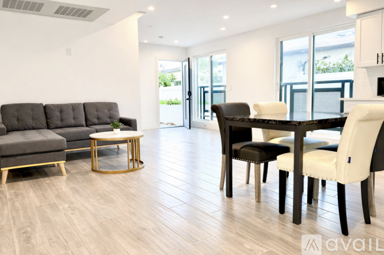 A living room with a grey sofa, black chairs and a coffee table.