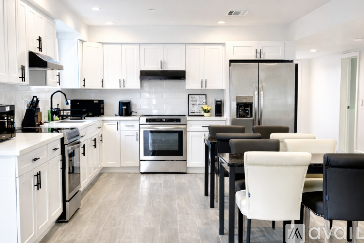 A modern kitchen with white cabinets and stainless steel appliances.