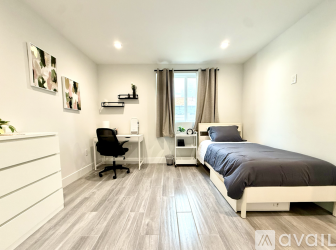 A bedroom with a bed, desk, and chair.