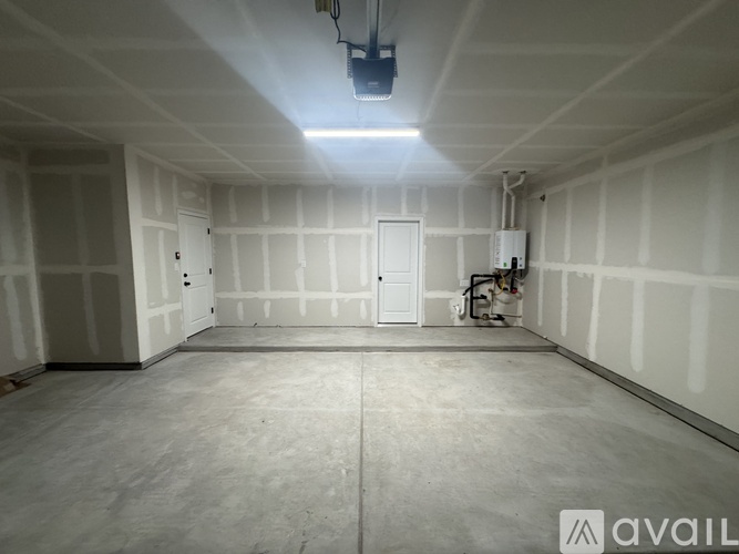 A large empty room with a light on the ceiling and a logo on the bottom right.