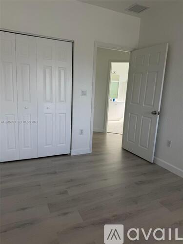 A room with two white doors and a wooden floor.