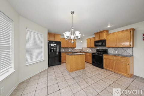A kitchen with wooden cabinets and black appliances.