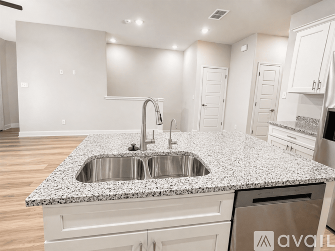 A kitchen with a granite countertop and stainless steel appliances.