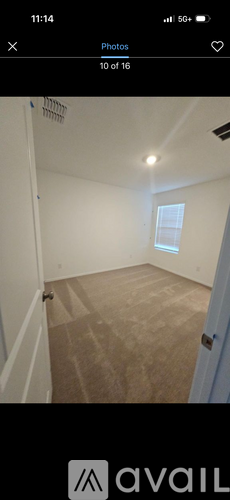 A room with a carpeted floor and a window.